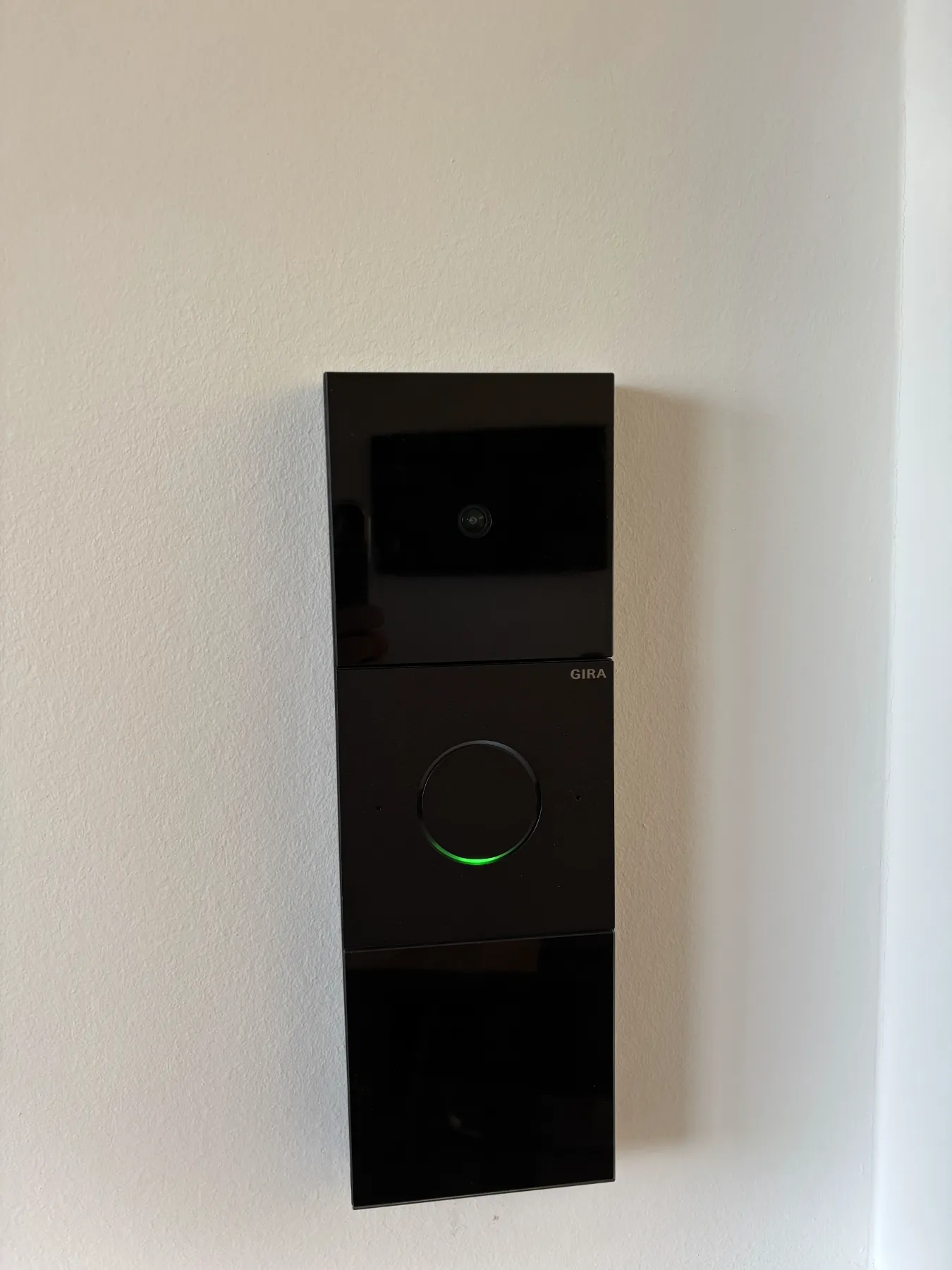 Gira Video-Türstation mit grünem Leuchtring an der Musterwand im Showroom