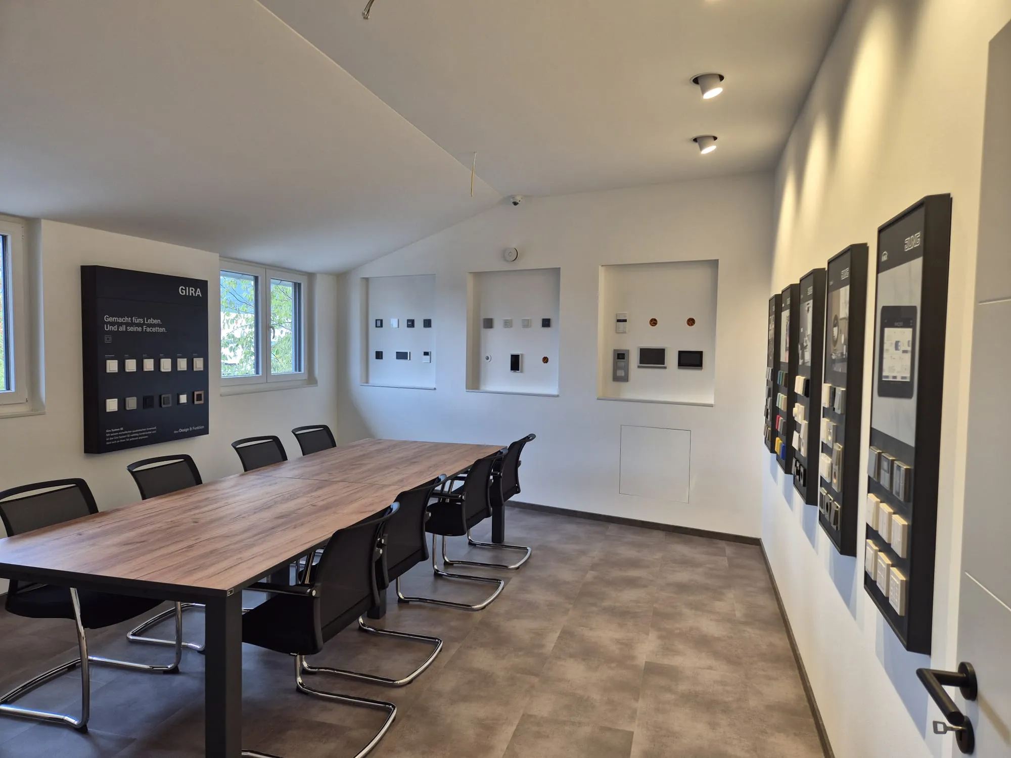 KNX-Showroom in Wiesloch: Besprechungstisch, Gira- und JUNG-Musterwände, Nischen mit Tastern und Türsprechanlage